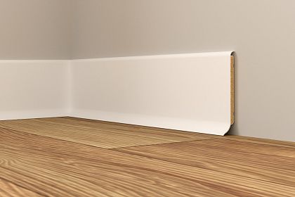 Nahaufnahme einer Ecke mit Holzfußboden und weißer Sockelleiste an der grauen Wand. Die Struktur des Holzes ist deutlich sichtbar, die Leiste sauber eingefügt.